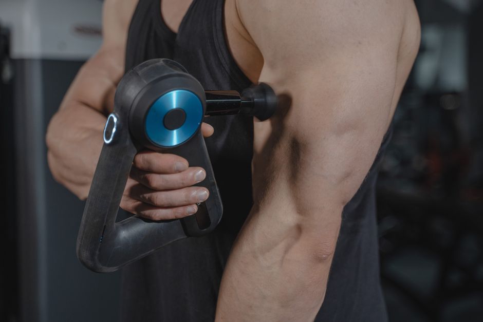 Budget percussion massage gun with attachments on a gym mat