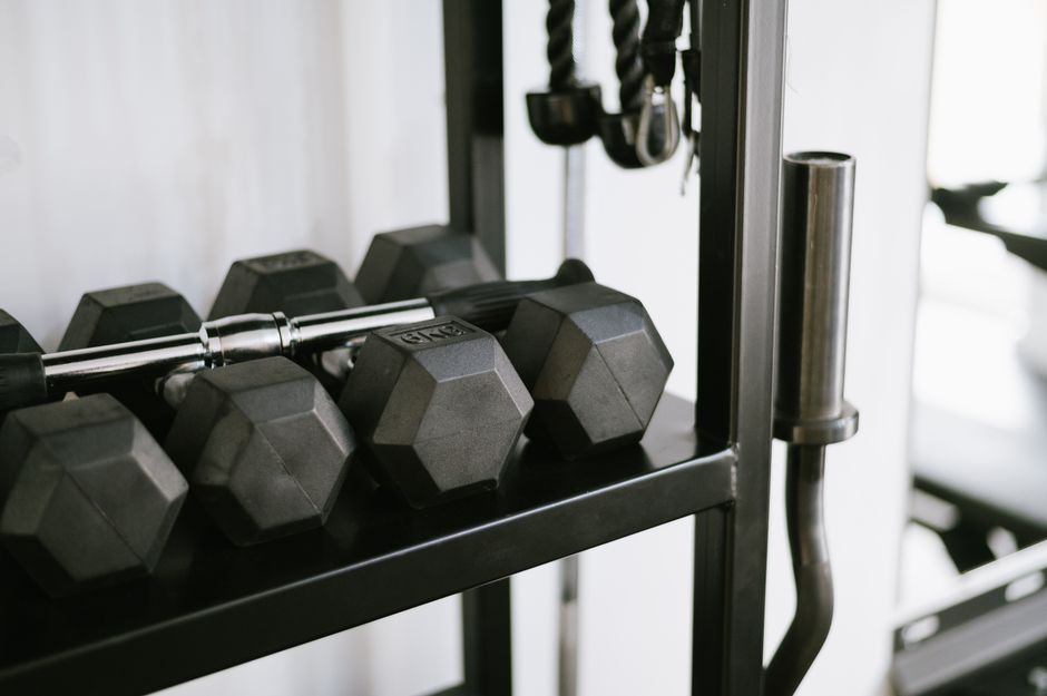 Compact adjustable dumbbells stored beside a home workout space